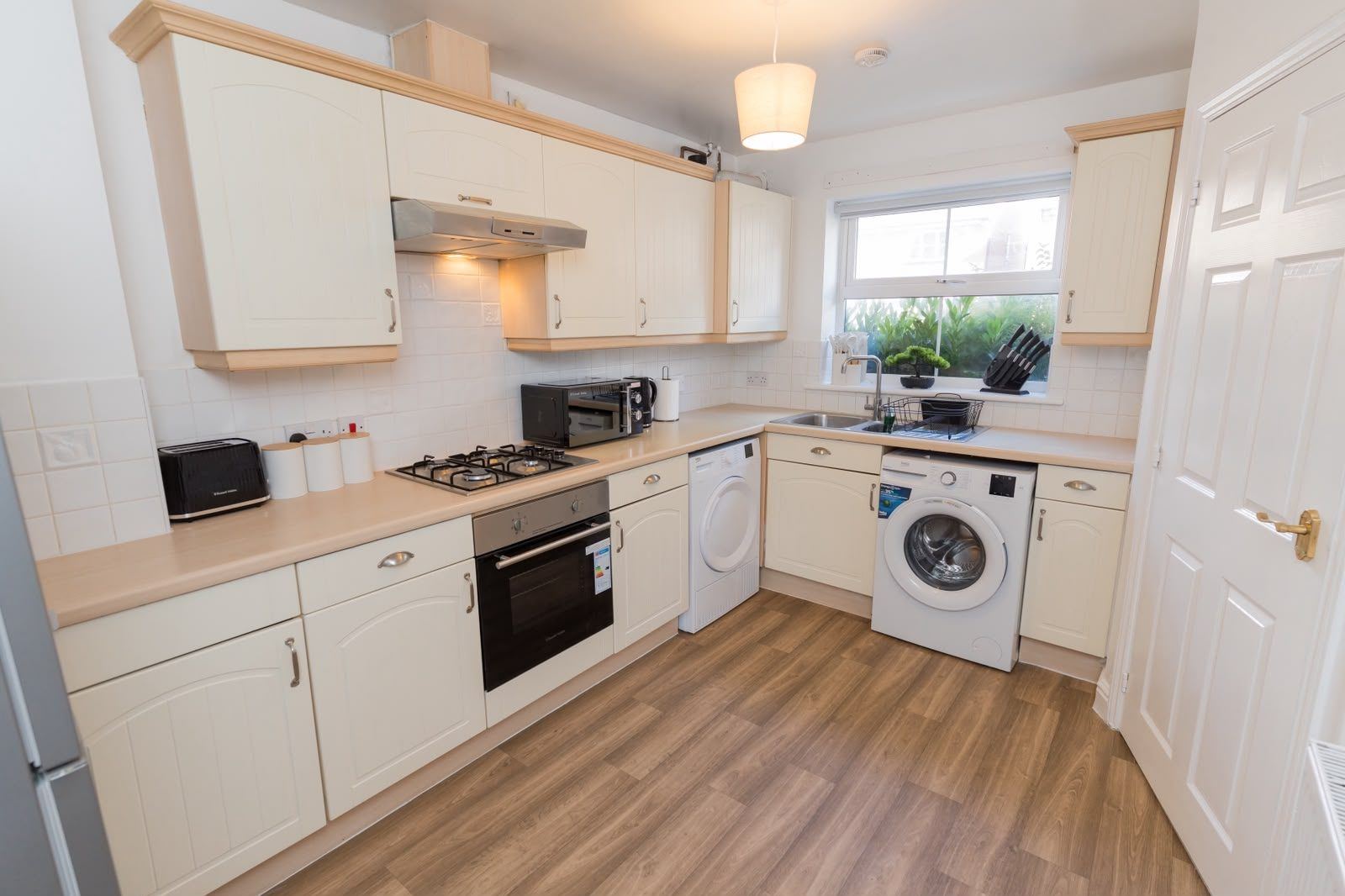 Kitchen with washing machine and tumble dryer